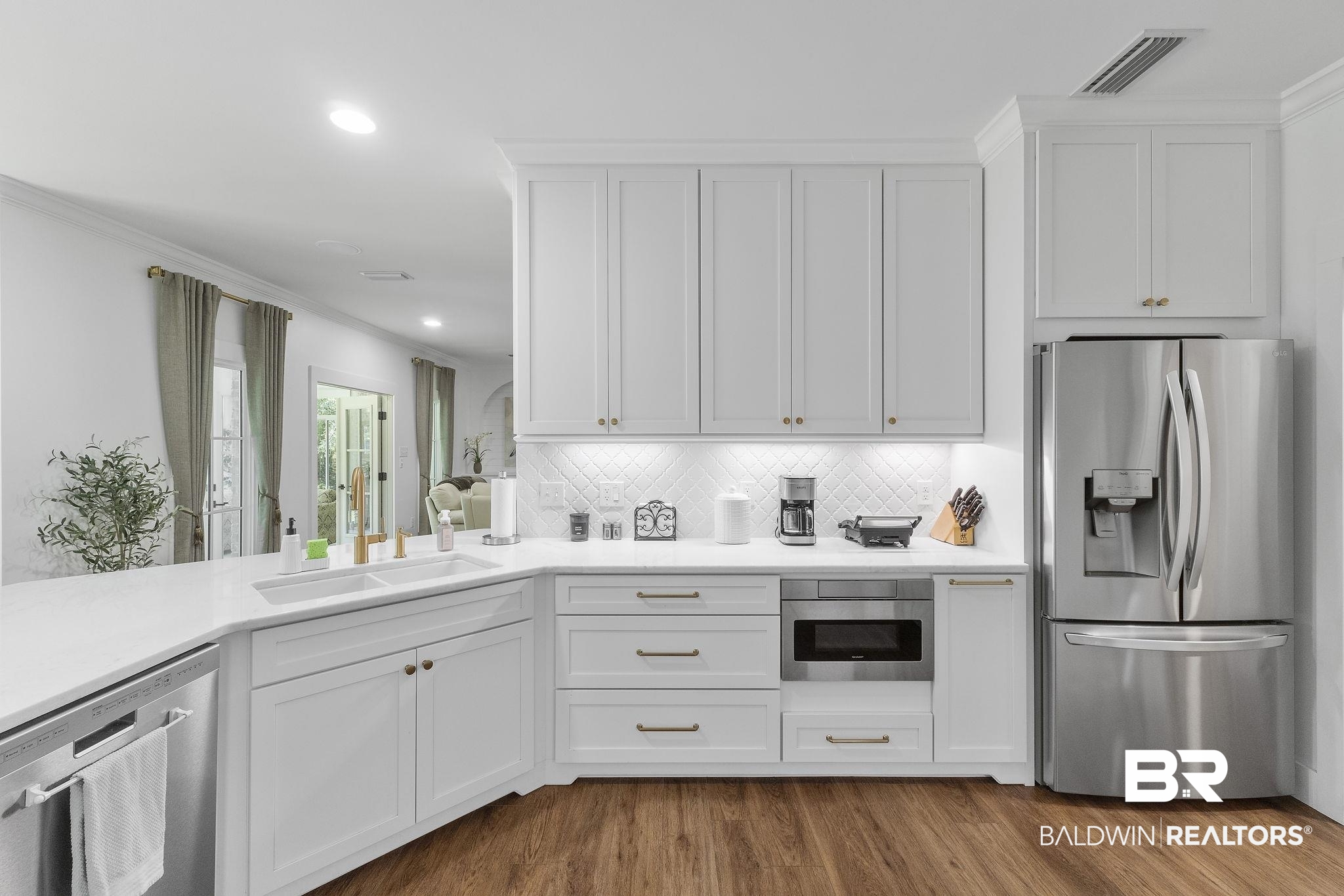 4451 Millhouse Road Gulf Shores, AL 36542 - Photo 21 of 50 Kitchen featuring appliances with stainless steel finishes, light hardwood / wood-style flooring, decorative backsplash, and sink