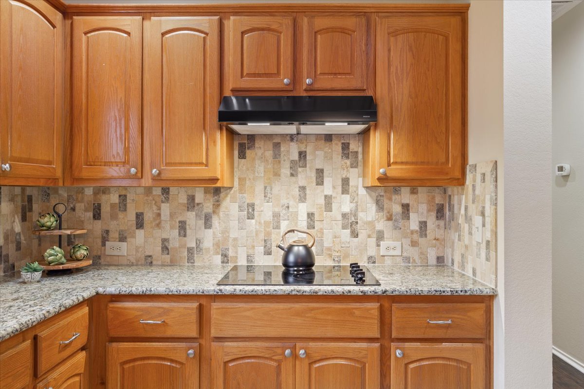 246 Red Poppy Trail Georgetown, TX 78633 - Photo 15 of 32 a kitchen with granite countertop a sink a stove and cabinets
