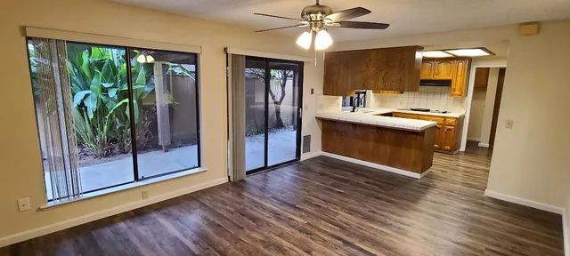 a kitchen with stainless steel appliances granite countertop a stove top oven a refrigerator a sink and a large window