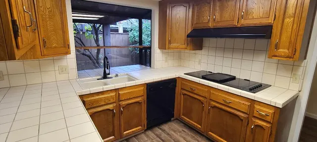 a kitchen with a sink a stove and cabinets