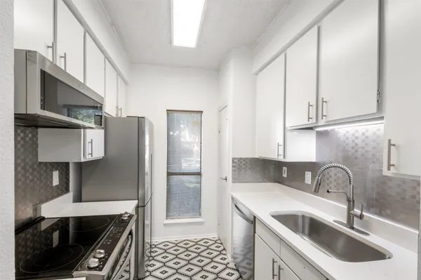 a kitchen with stainless steel appliances a sink stove and refrigerator