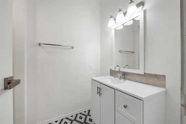 a bathroom with a sink vanity and a mirror