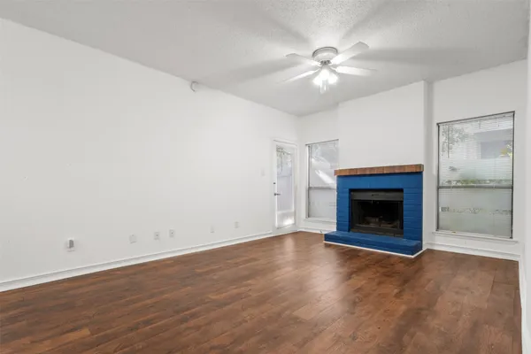 an empty room with fan and a fireplace