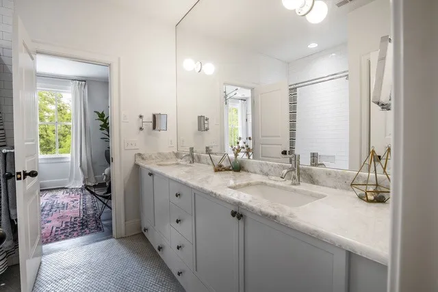 a spacious bathroom with double sink and a mirror