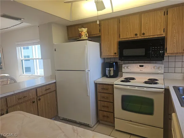 a kitchen with stainless steel appliances granite countertop a sink and a refrigerator