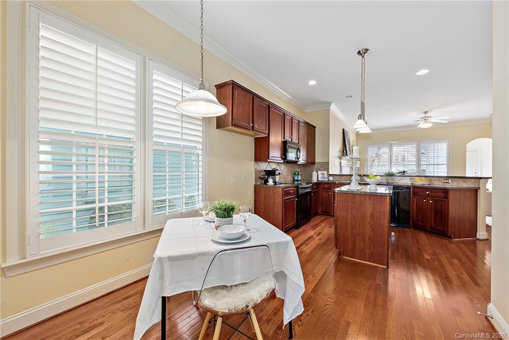 527 Fourth Baxter Crossing Fort Mill, SC 29708 - Photo 11 of 27 a dining room with stainless steel appliances kitchen island granite countertop a table chairs and a view of kitchen