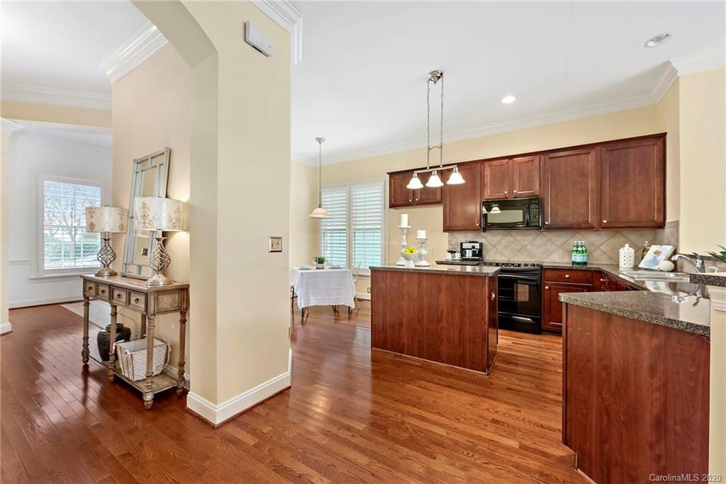 527 Fourth Baxter Crossing Fort Mill, SC 29708 - Photo 12 of 27 a kitchen with stainless steel appliances granite countertop wooden cabinets a refrigerator a stove a sink and a wooden floors