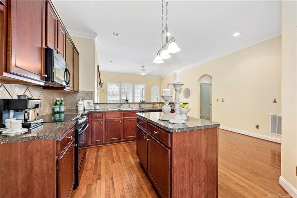 527 Fourth Baxter Crossing Fort Mill, SC 29708 - Photo 13 of 27 a kitchen with stainless steel appliances granite countertop a sink a stove and a wooden floors