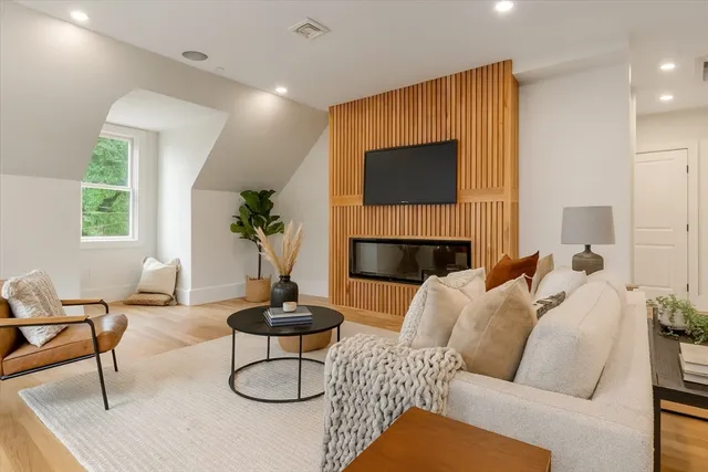 a living room with furniture a fireplace and a potted plant