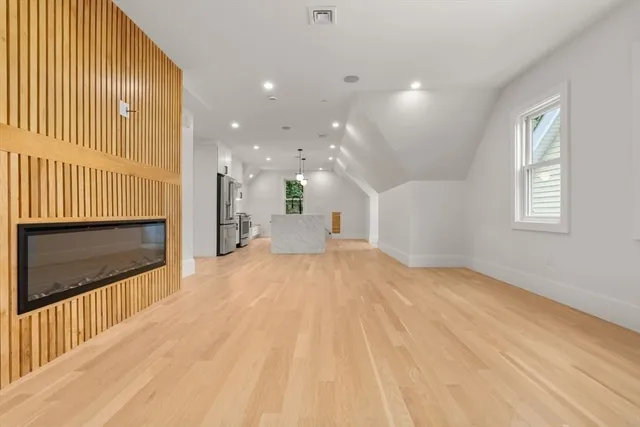 a view of empty room with wooden floor and fireplace