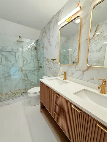 a bathroom with a sink a toilet and shower