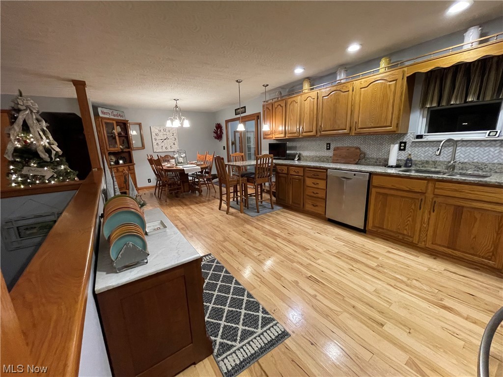 Kitchen featuring stainless steel dishwasher, hickory floors
