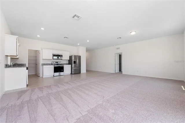 a view of kitchen with stainless steel appliances refrigerator stove microwave and stove