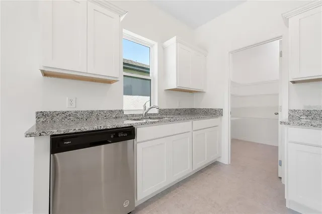 a kitchen with granite countertop a sink and cabinets