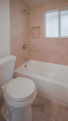 a white toilet sitting next to a bath tub