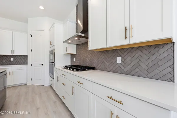 a kitchen with granite countertop white cabinets and white appliances