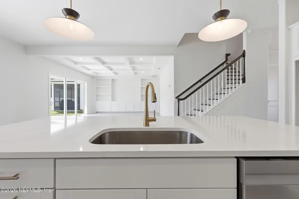 a kitchen with a sink cabinets and a chandelier