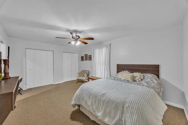 a bedroom with a bed and a ceiling fan