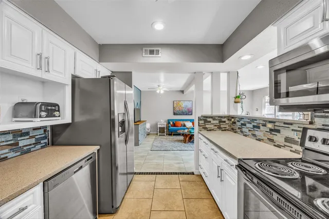a kitchen with stainless steel appliances a stove a sink and a refrigerator