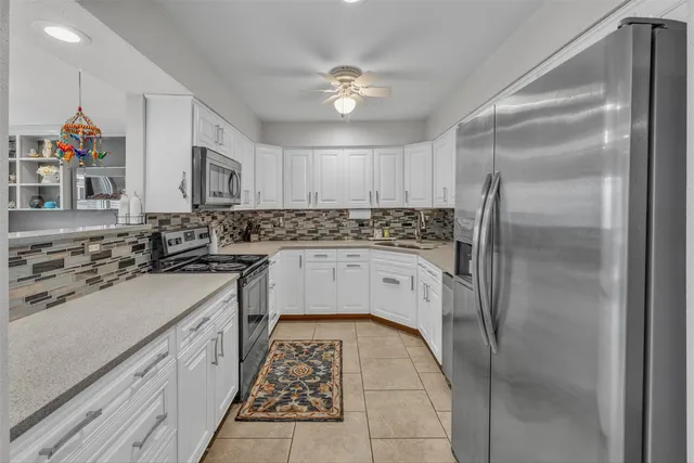 a kitchen with a sink a refrigerator and cabinets