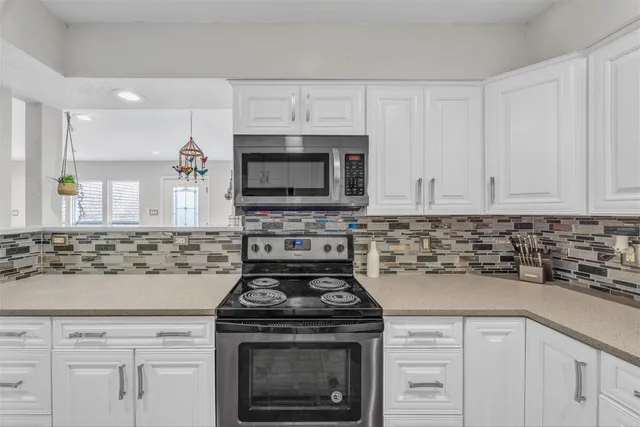 a kitchen with stove a microwave and cabinets