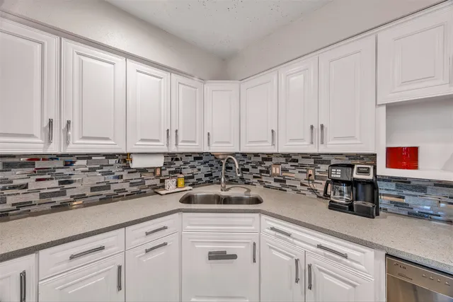 a kitchen with white cabinets and white appliances