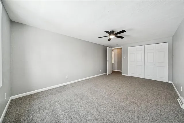a view of an empty room with a ceiling fan