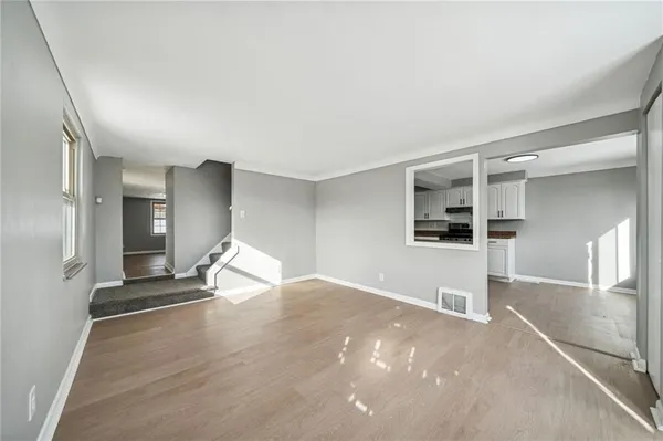 a view of empty room with wooden floor