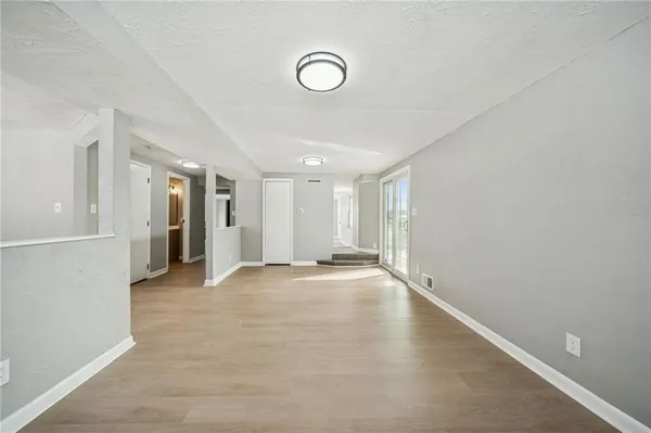 a view of an empty room with wooden floor