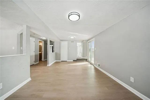 a view of an empty room with wooden floor