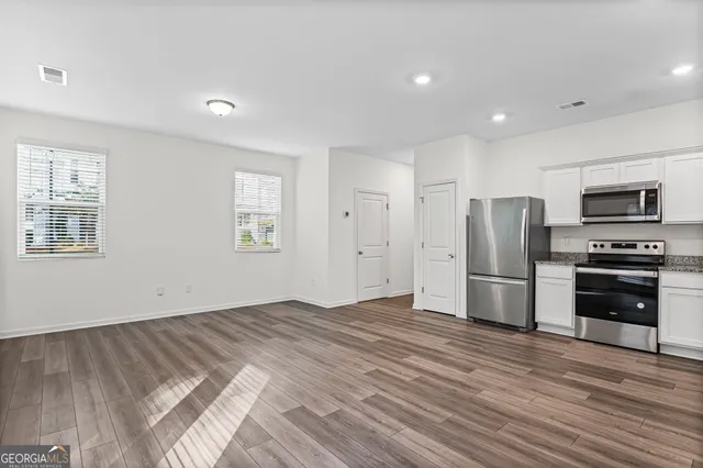 a view of kitchen with refrigerator microwave and stove top oven