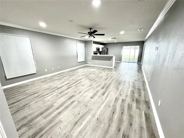 a view of empty room with wooden floor