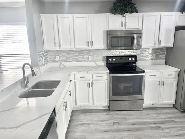 a kitchen with granite countertop a sink and a stove top oven
