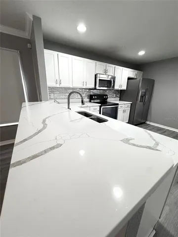 a large white bedroom with a large bed and furniture