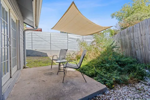 a view of a chair and table in backyard of the house
