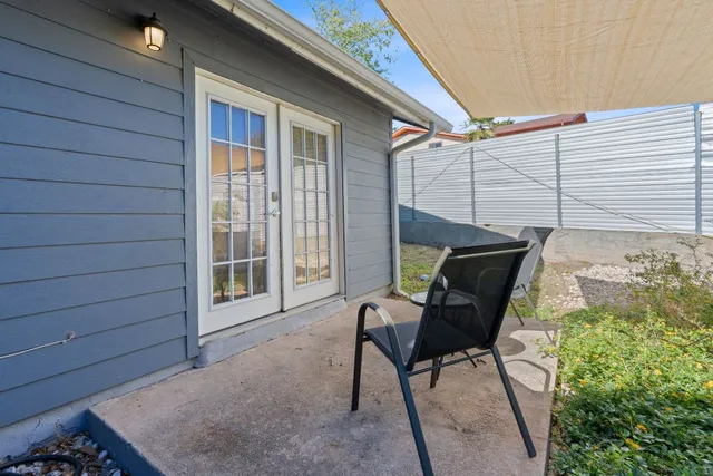 a view of backyard with a table and chair under an umbrella