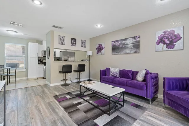 a living room with furniture a flat screen tv and a table