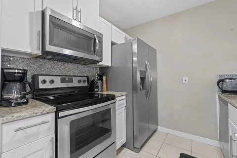a kitchen with granite countertop cabinets stainless steel appliances and a counter space