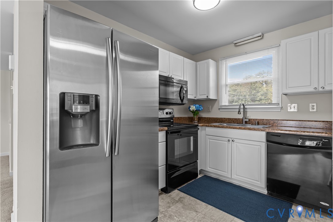 4801 Penick Road Richmond, VA 23228 - Photo 12 of 39 Kitchen with black appliances, white cabinetry, an