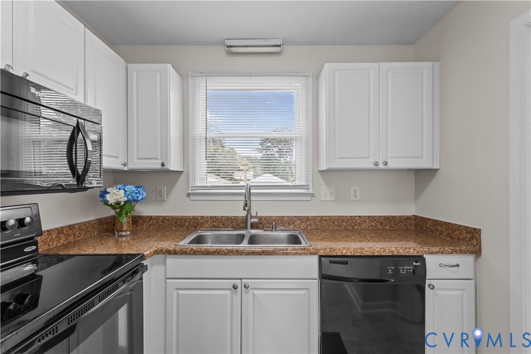4801 Penick Road Richmond, VA 23228 - Photo 13 of 39 Kitchen with black appliances and white cabinetry