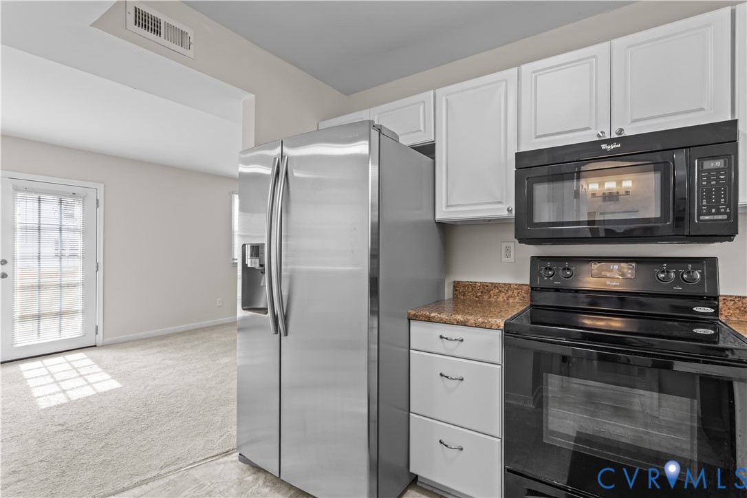 4801 Penick Road Richmond, VA 23228 - Photo 14 of 39 Kitchen with black appliances, white cabinetry