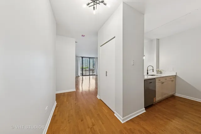 a view of a kitchen from the hallway with wooden floor