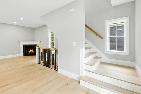 a view of a livingroom with wooden floor and a fireplace