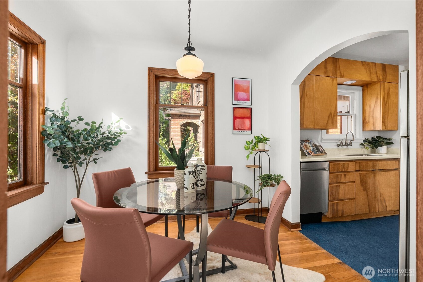 8606 29th Avenue Northwest Seattle, WA 98117 - Photo 6 of 33 a dining room with furniture potted plants and wooden floor