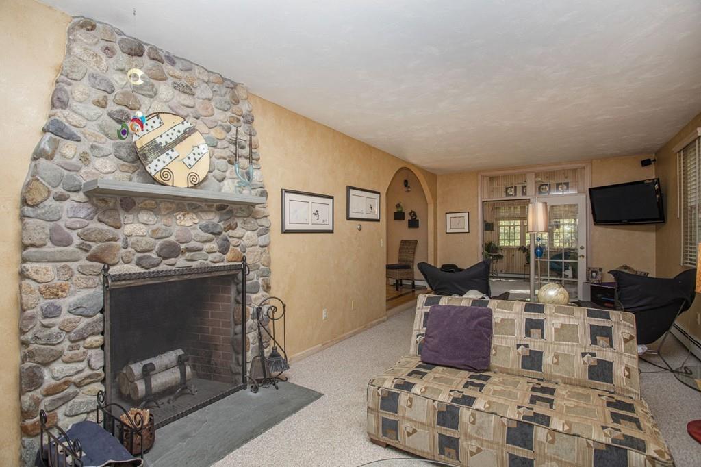 50 Lady Slipper Road Bridgewater, MA 02324 - Photo 13 of 37 a living room with furniture a flat screen tv and a fireplace