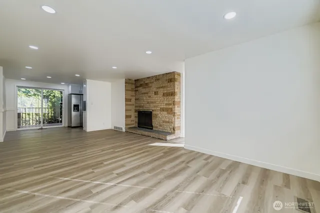 an empty room with wooden floor and fireplace