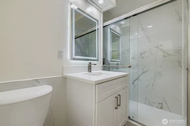 a bathroom with a sink a toilet and shower