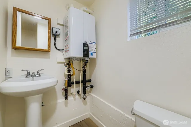 a bathroom with a sink vanity mirror and toilet