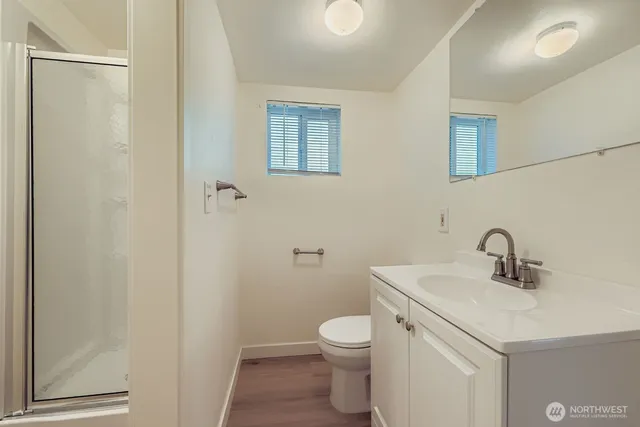 a bathroom with a sink a toilet and shower
