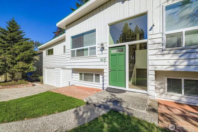 a view of a house with a yard and large tree